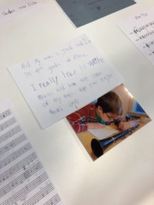 A photo of Jack writing music and a sign with his written introduction