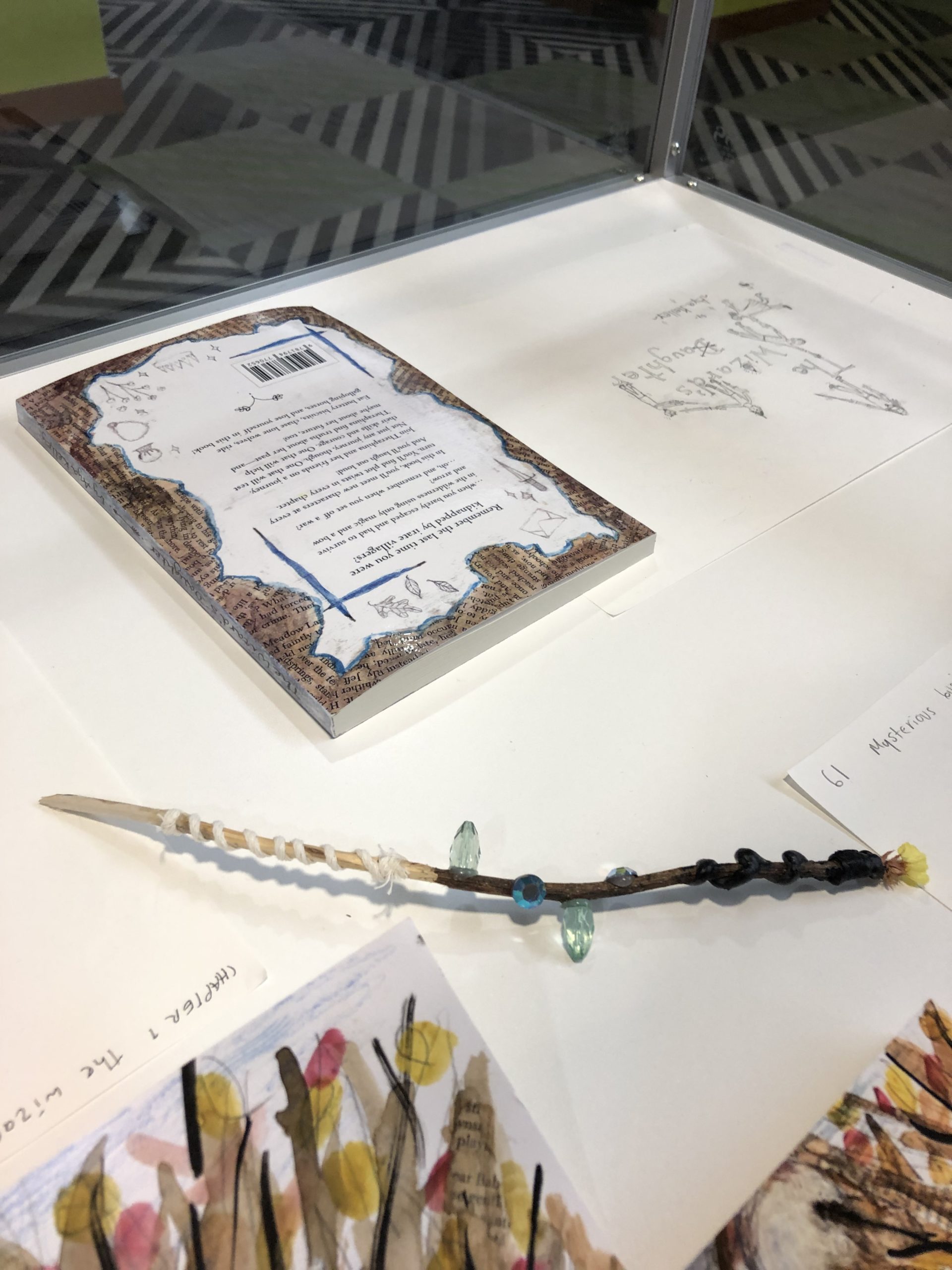 Back of book and wand made from a twig, twine, and beads