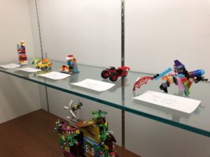 Collection of assorted LEGO sculptures in a display case