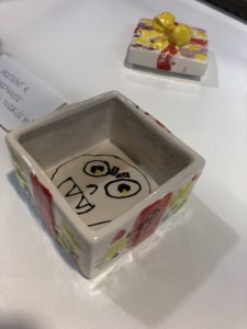 Close-up of a ceramic box with a face painted on the inside
