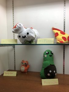 Display of sewn and stuffed sushi, pizza, fox, and avocado