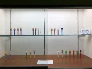 Display case of Pez dispensers, including U.S. Presidents, Frozen characters, and holiday-themed Pez