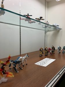 Display case of collection of LEGO figurines, including a horse and unicorn