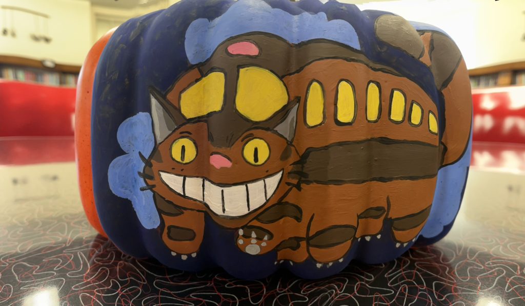 A pumpkin painted with the catbus character from My Neighbor Totoro.