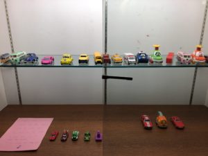 A display case featuring a collection of toy cars