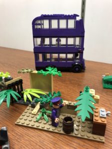 LEGO creations in a display case, including triple-decker bus and sculpture made with LEGO leaves