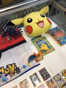 Pokémon cards, handbooks, and Pikachu plush toy.