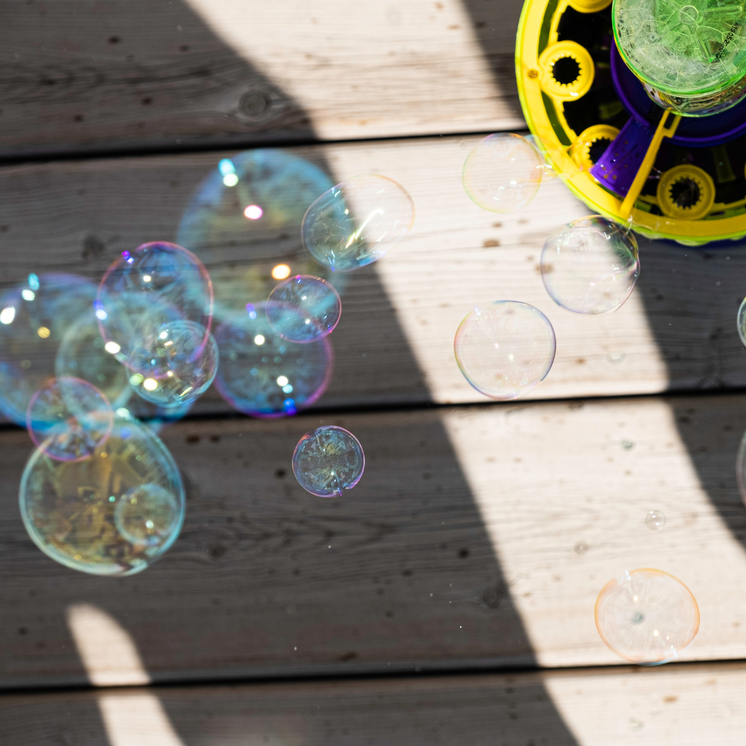 a bubble machine blows bubbles with a background of a porch