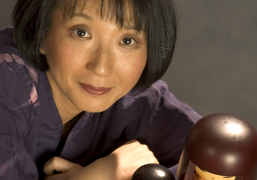photo of storyteller Motoko with two Japanese dolls