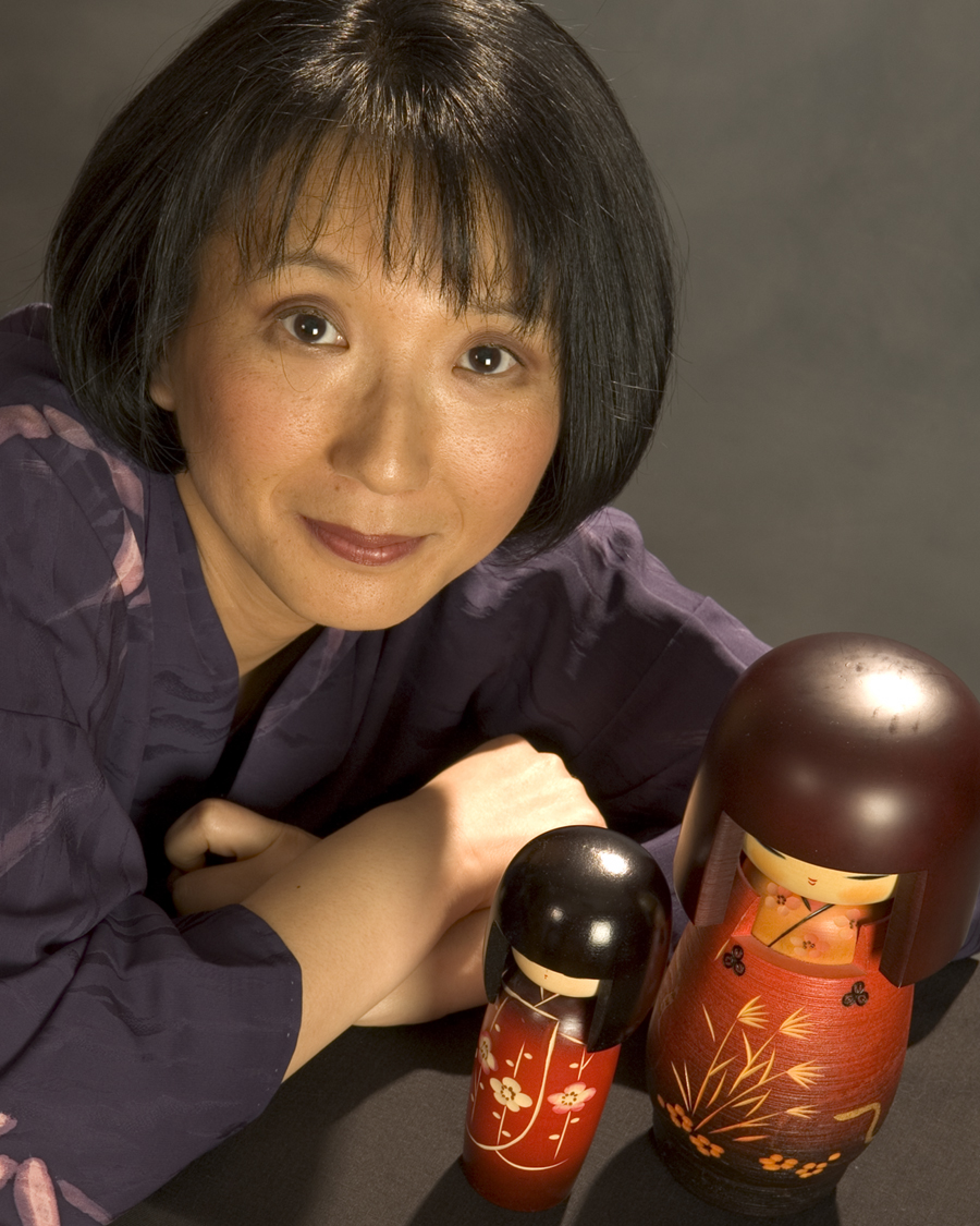 photo of storyteller Motoko with two Japanese dolls