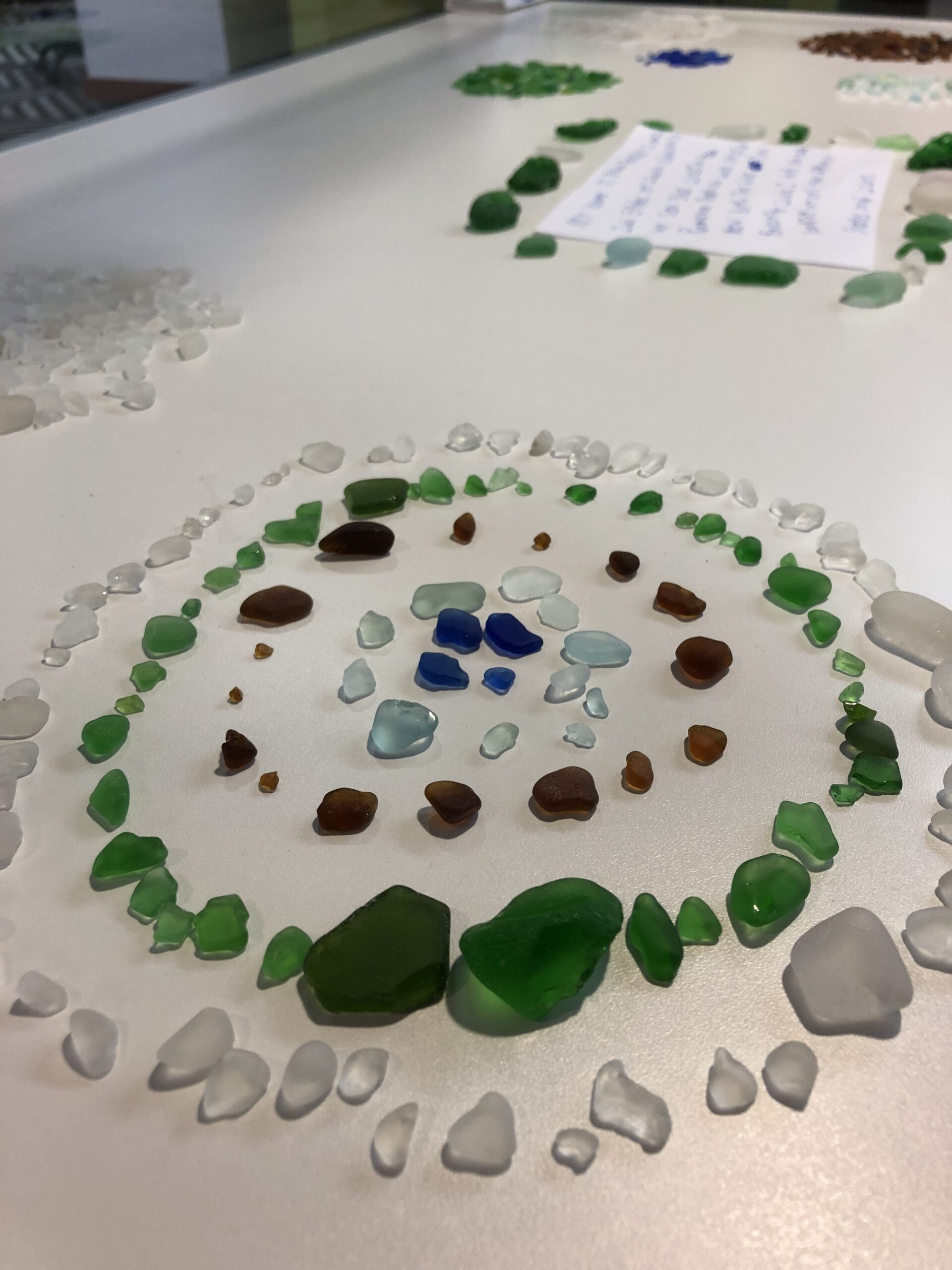 A collection of colored sea glass in a mandala-like pattern
