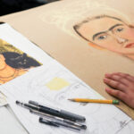 Photo of a sketch and color drawings of Frida Kahlo.