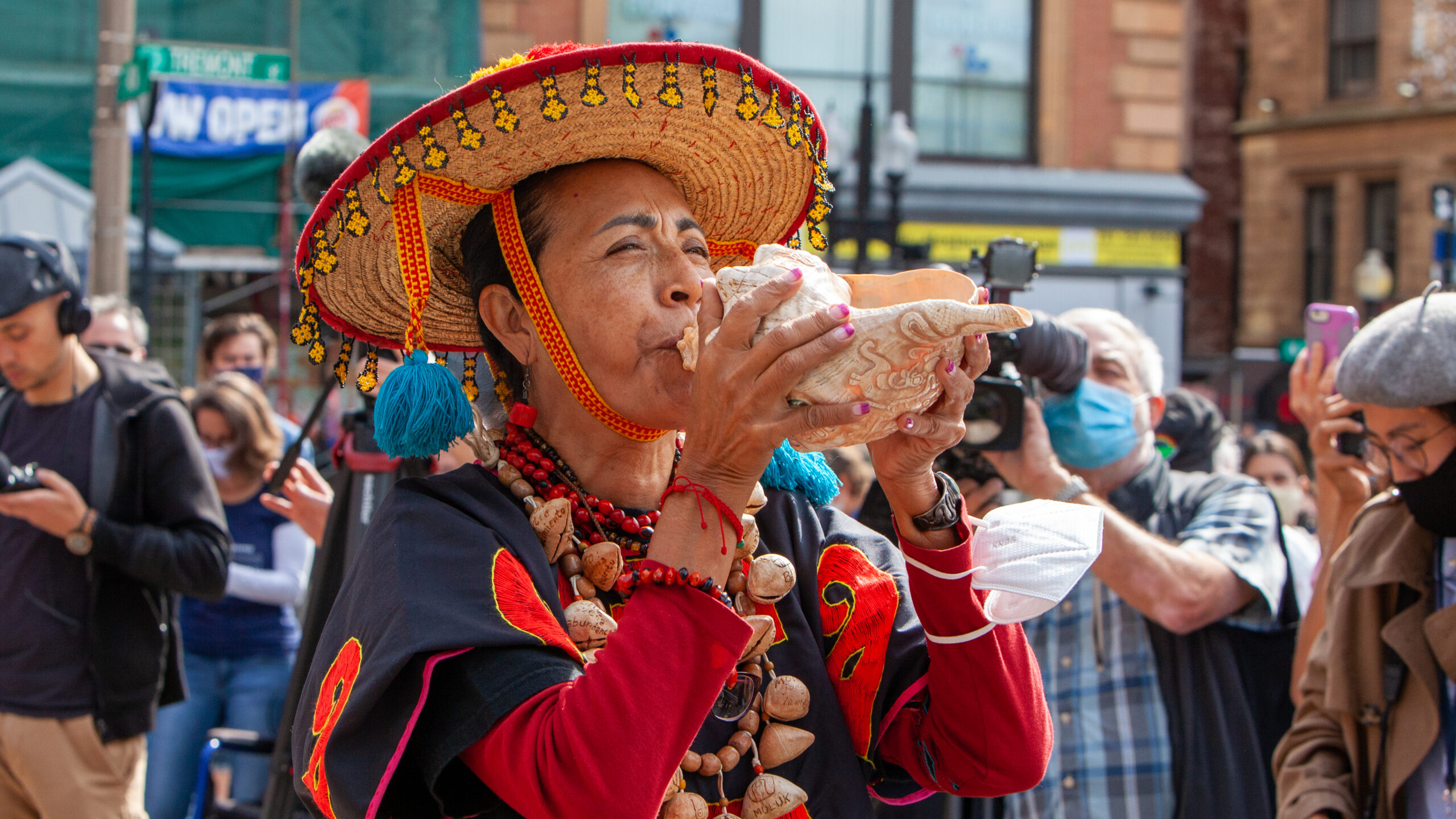 Rosalba Solis at a street festival, playing a conch shell