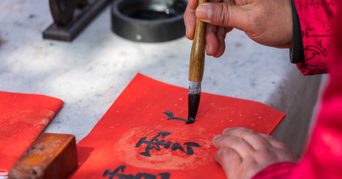 Hand painting red calligraphy paper with an ink brush