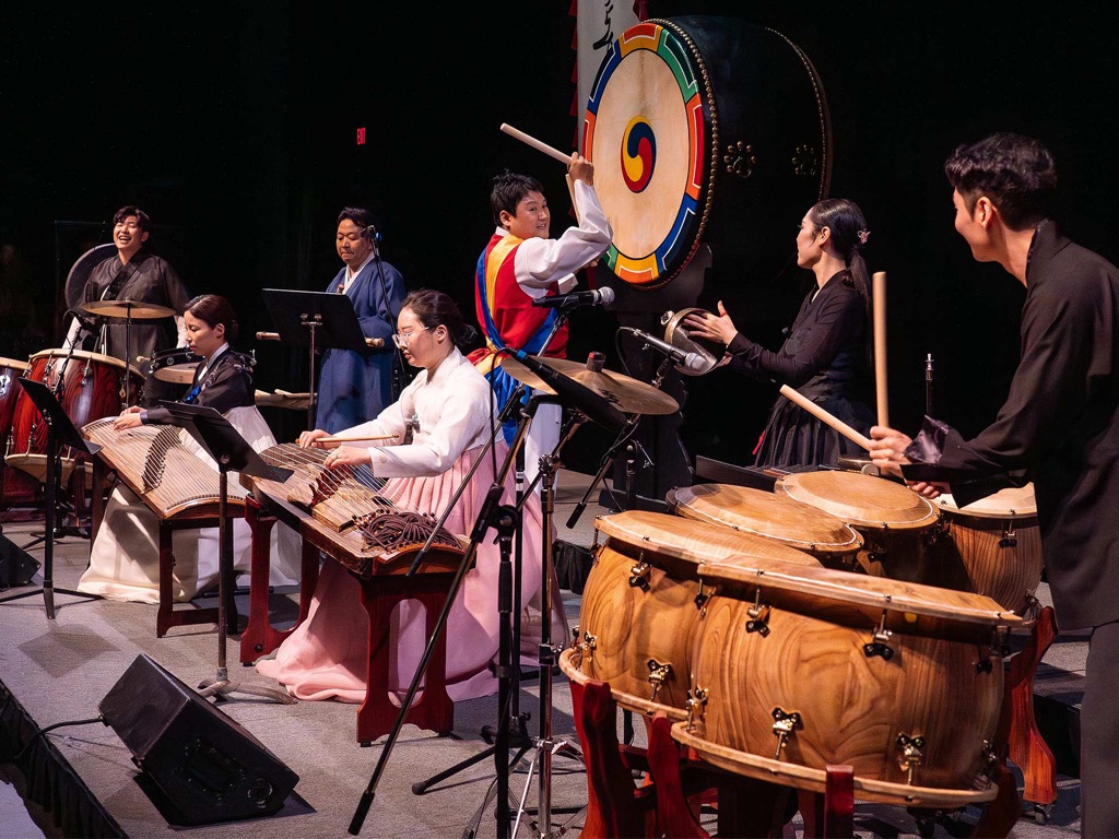 Instrumentalists playing drums, gongs, and string instruments