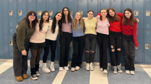 photo of acapella group posed against lockers