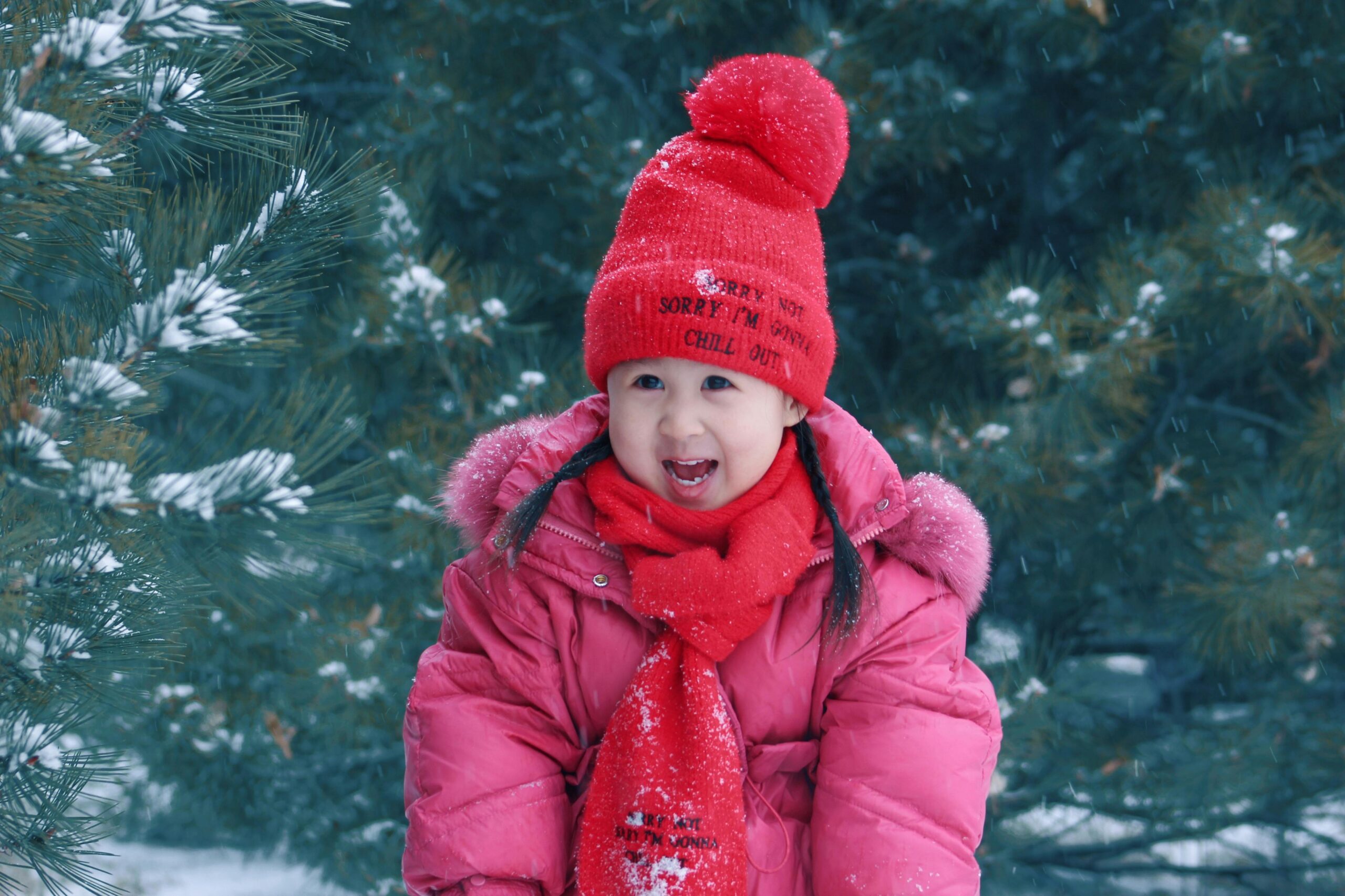 Happy child in winter coat and hat playing outside