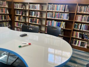 bookshelves and whiteboard table with markers